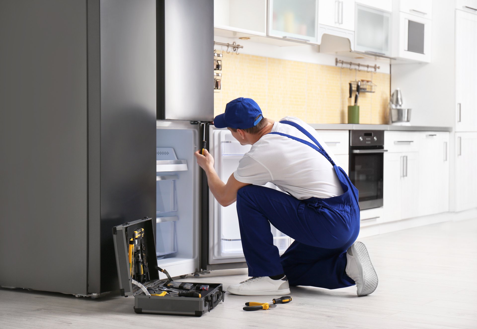 a technician repairing a refrigerator - Appliance Repair Mount Pleasant Pros